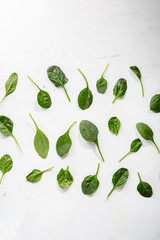 Baby spinach leaves on white surface