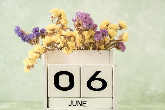 White cube calendar for june on green background with copy space