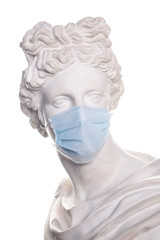 gypsum statue in a medical mask isolated on white background. coronavirus pandemic.