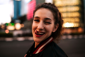Beautiful spanish woman listening to music with earphones and smart phone outdoors in the night city