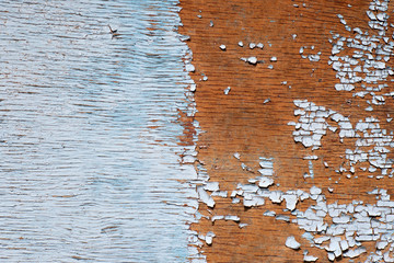 The old wooden wall is half-painted. Damaged concrete rough texture on wooden wall. texture of wooden boards with peeling paint