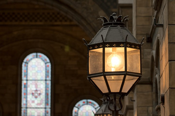 Old style metal and glass wall lamp in religious building