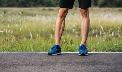 Runner man feet running on road closeup on shoe. Sports healthy lifestyle concept.