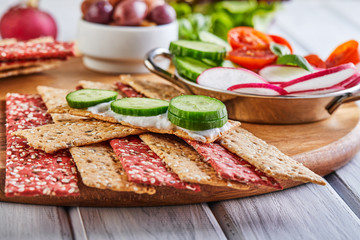 Beetroot and rye flour crackers with vegetables for making snacks on a wooden background. Vegetarianism and healthy eating
