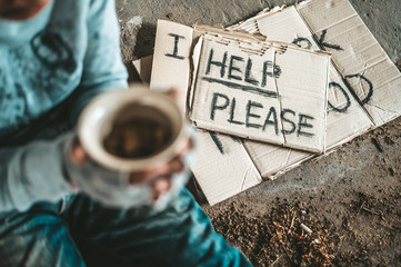 Beggars sitting under a bridge with cups have money.