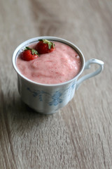 Banana and strawberry nice cream in a vintage porcelain cup. Selective focus.