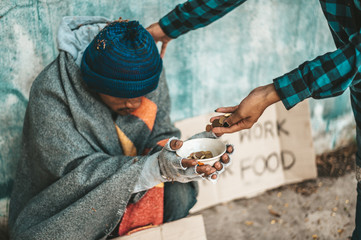 Beggars sitting under the overpass with a credit card and credit card swipe machine