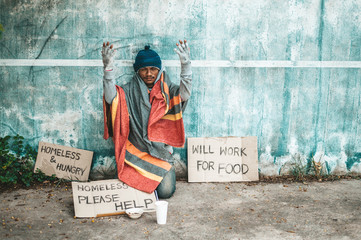 The beggars sat beside the street with a homeless message. Please help and work with food.
