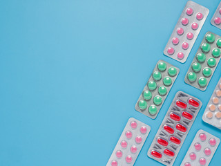 Different colorful pills on blue background, flat lay