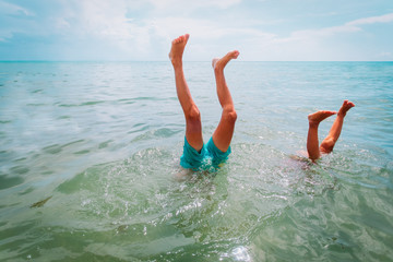 kids making handstand in sea, kids vacation fun