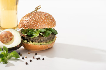 delicious green vegan burger with microgreens, avocado, black pepper on white background