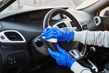 Female hand spraying sanitizer and antiseptic wet wipes for disinfecting car. Cleanliness and healthcare during Corona virus, COVID-19.