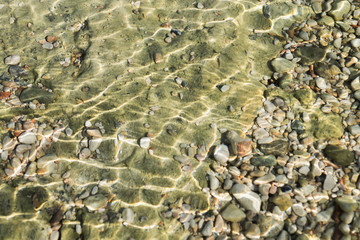 Pure clear sea water. The texture of sea stones.