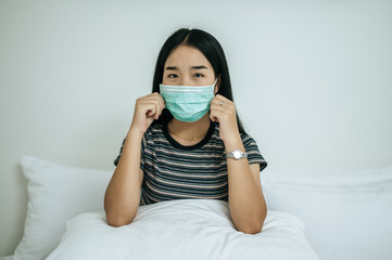 A woman wearing a striped shirt wearing a mask.