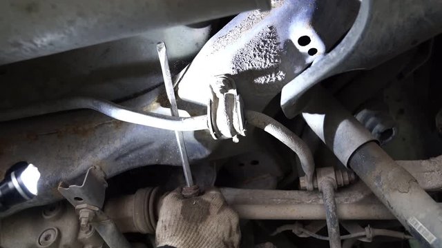 Inspection of the undercarriage of the car in the garage.