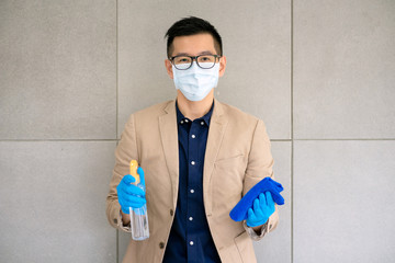 Businessman wearing face mask and using personal sanitizer to cleaning her hand in office to keep hygiene preventive epidemic from coronavirus or covid19