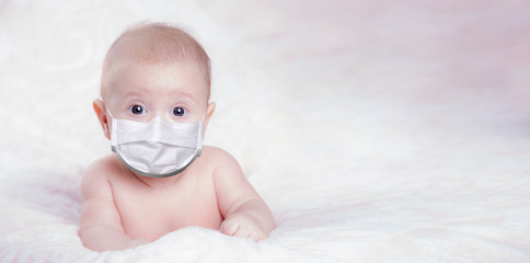 The baby is in a medical mask is lying on the bed. Concept pandemic coronavirus Covid 19