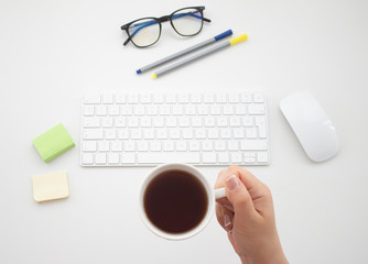 Take a break and drink tea. Topview office desktop. Keyboard, mouse, office materials. 