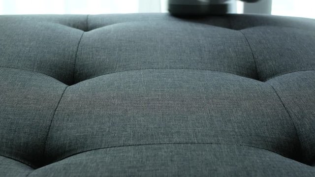 Close-up view of the dust mite vacuum cleaning the sofa to get rid of dust and dust mites that cause allergies.