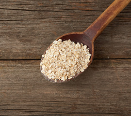 oatmeal flakes in a wooden spoon on the table