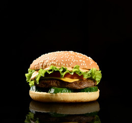 Burger cheeseburger bbq sandwich with beef cheese and fresh vegetables hot with steam smoke on black