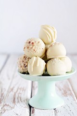 Chocolate truffle candies on white chocolate with nuts. Chocolate sweets on a light background, homemade sweets