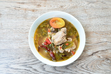 hot and spicy pork bone with tamarind leaf and Thai herbs soup on bowl 