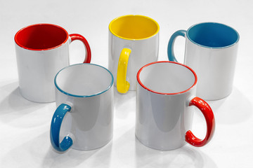 set of colored mugs for sublimation on a white background, a colored middle and a pen. Different colors
