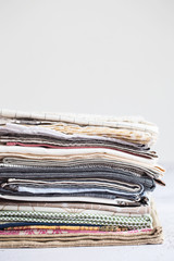 kitchen textile. stack of fabrics in different colors and textures, close-up. Kitchen towels on white background. Many fabric kitchen napkins in a wicker basket. Props for foodphotography