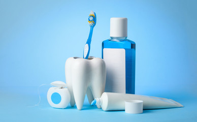 Set for cleaning teeth and mouth. Toothpaste, toothbrush, dental floss and mouthwash on a blue...