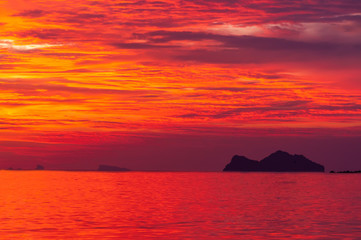 Fiery red sunset overlooking a small island
