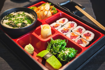 Vegan sushi bento lunch with miso soup, vegetable maki, avocado and seaweed gunkan