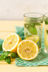 A glass of lemonade with lemon and mint, on a hot summer day.