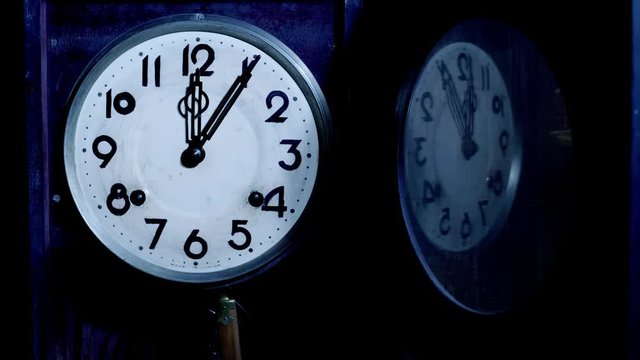 Close up of antique pendulum wall clock on midnight
