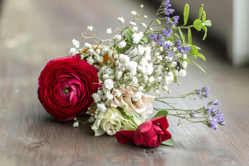 Original bouquet at the floor. Wooden floor with flowers. Present at the anniversary. Printing for postcard. Image with selective focus.