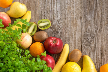 Various fruits lying diagonally on an old wooden background.