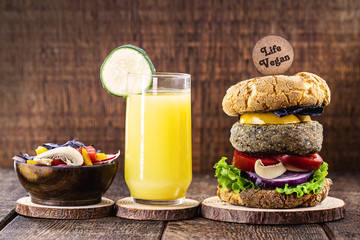 vegan snack, meatless hamburger, with small plate written in English Vegan life. Gluten-free meal, made with different vegetables and proteins.