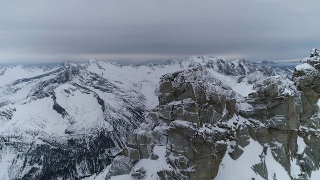 Huge snowy rock formation overlooking lake in Austrian Alps