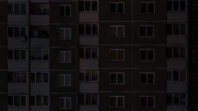dimming light in the window of an apartment building at night. life in big city. concept for a couple in love on isolation