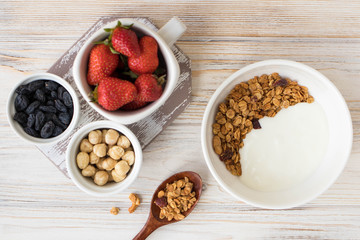 Plate with muesli, nuts and strawberries, healthy breakfast