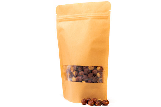 yellow food packaging in paper, plain doypack standup bag filled with hazelnut with window and zipper on white background