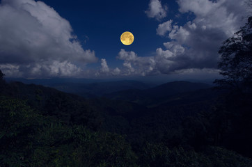 Full moon with white clouds over the valley