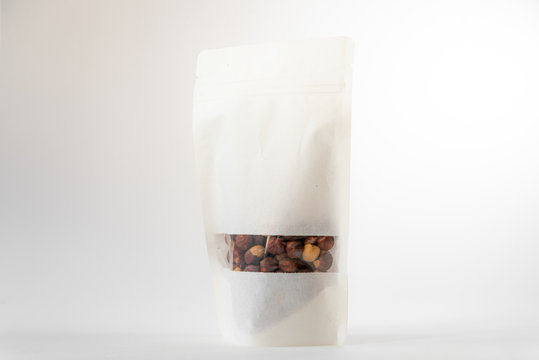 white paper doypack eco friendly food package filled with hazels with window and zipper on white background