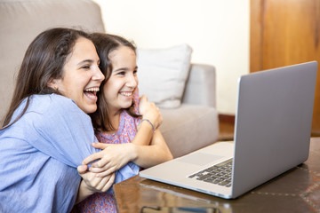 Happy girls at home with laptop