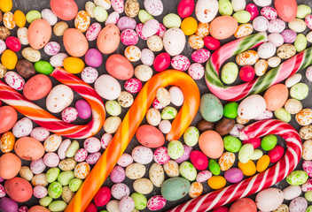 Colorful multicolored candies on a black concrete background. close up, top view.