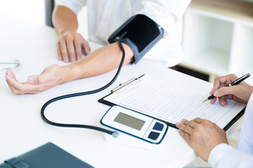 Doctor measuring patients blood pressure in hospital.
