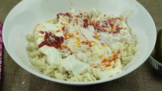 Turkish stile spiral pasta is served with yogurt and tomato sauce