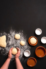 Obraz na płótnie Canvas Baking bread buns at home. Woman hands shaping the dough