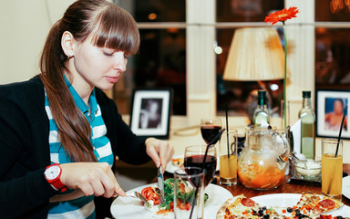 Portrait of young girl eating food in restaurant reflex