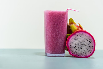 Pitaya fruit juice (Hylocereus polyrhizus) on green surface and white background